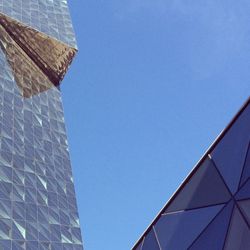 Low angle view of modern building against clear blue sky
