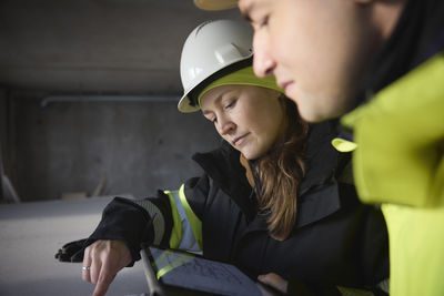 Engineers checking plans on digital tablet