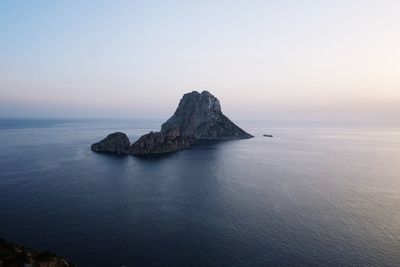 Rock formation in sea against sky