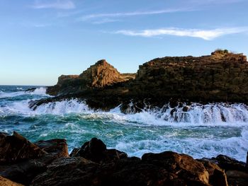 Rock formations by sea against sky