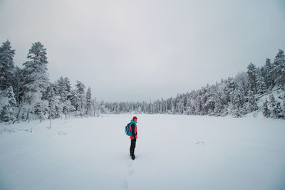 Young explorer in colorful jacket stands in frosty white environment in sotkamo, finland