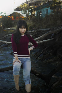 Portrait of smiling young woman standing on land