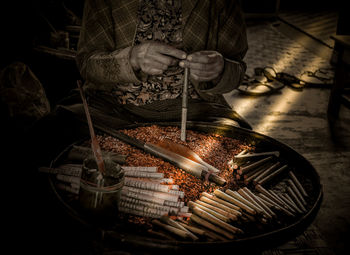 Close-up of man preparing food on barbecue grill