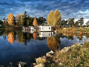 Scenic view of lake by trees against sky