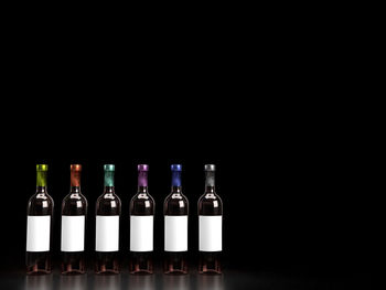 Glass of bottles against black background