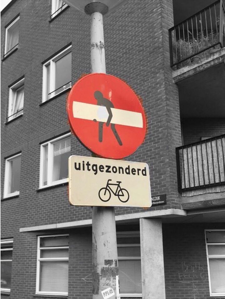 LOW ANGLE VIEW OF ROAD SIGN AGAINST BUILDINGS