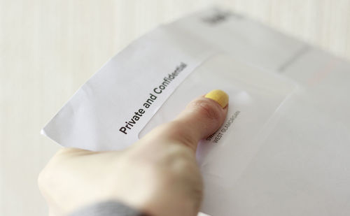 Close-up of human hand holding paper