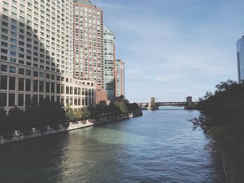 River amidst buildings in city against sky