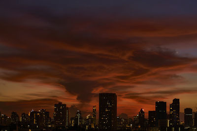 Illuminated buildings against sky during sunset