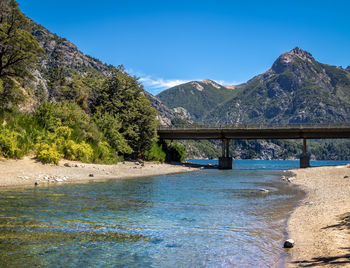 Bridge over mountains against clear sky