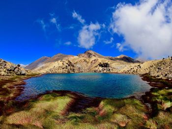 Scenic view of lake and mountains against blue sky