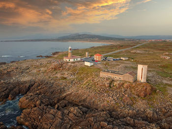 High angle view of sea and buildings against sky during sunset