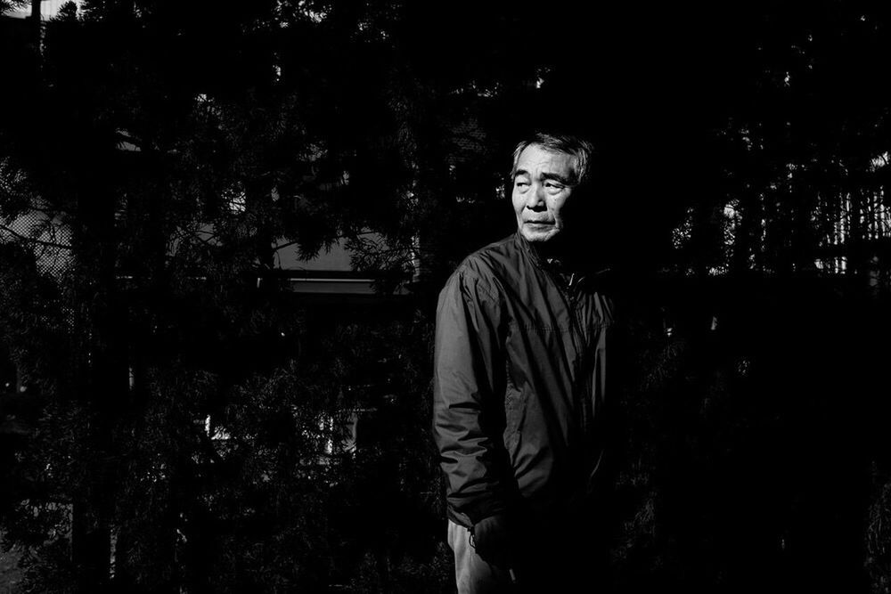 PORTRAIT OF YOUNG MAN STANDING AGAINST PLANTS