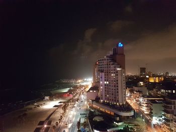 Illuminated cityscape against sky at night