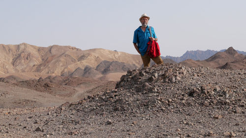 Senior man standing on mountain in the desert 