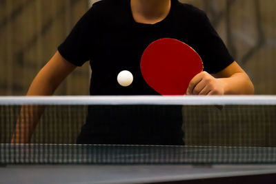 Midsection of man playing table tennis