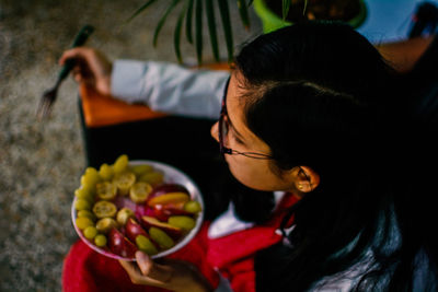 Side view of woman holding food