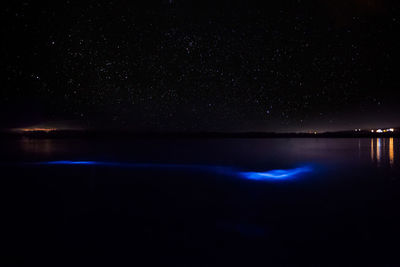 Scenic view of lake against sky at night