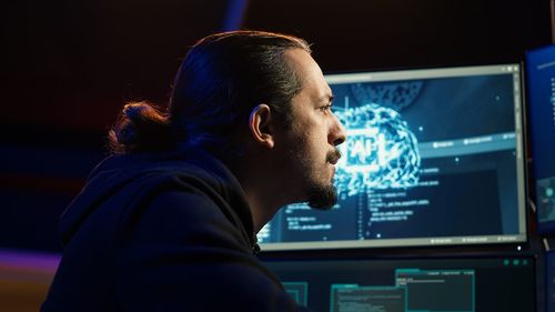 Side view of man looking through window
