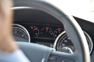 Closeup image of car dashboard through steering wheel during the day