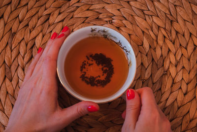 High angle view of hand holding tea cup