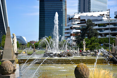 Water fountain against buildings in city