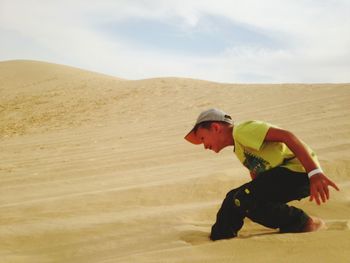 Side view of man on sand dune in desert