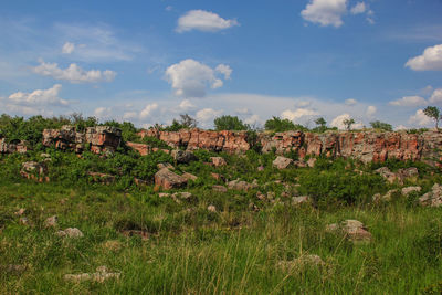 Rock formation on grassy field against sky at pipestone national monument