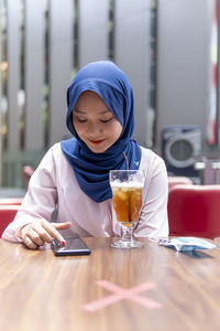 Boy drinking glass on table