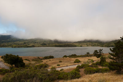 Scenic view of lake against cloudy sky