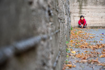 Woman on rock against wall