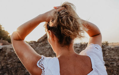 Close-up of young woman standing on beach against sky