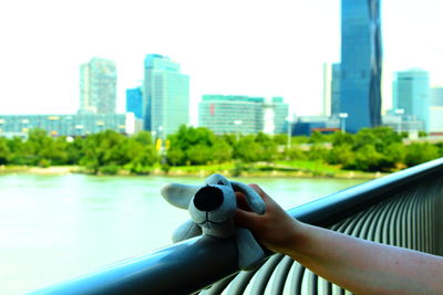 Close-up of hand against cityscape