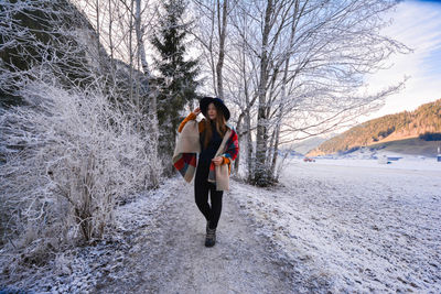 Woman standing on snow covered tree