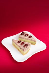 Close-up of cake on plate against red background