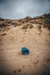 Drink can at beach against sky