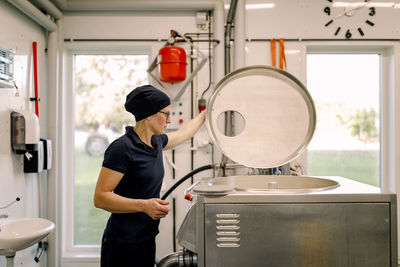 Farmer examining machine at dairy factory