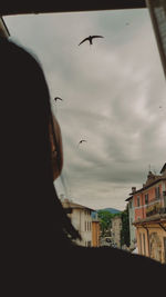 Low angle view of silhouette birds flying against sky during sunset