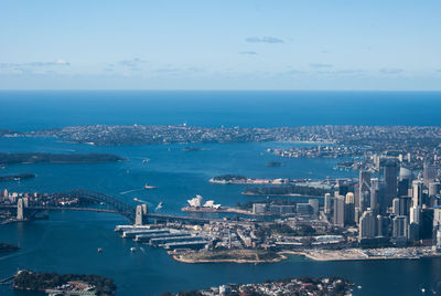 High angle view of city by sea against sky
