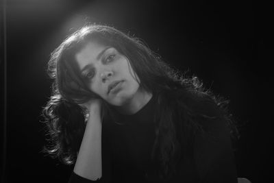 Portrait of a beautiful young woman over black background