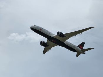 Low angle view of airplane flying against sky