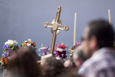 Low angle view of people carrying cross on street during easter procession