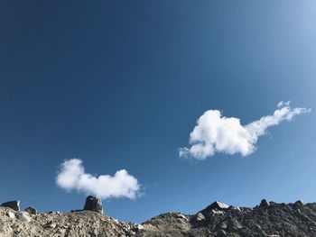 Low angle view of rocks against blue sky