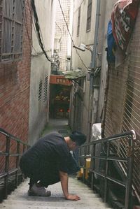 Full length rear view of man standing on street against building