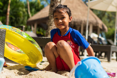 Portrait of girl playing with toy in beach