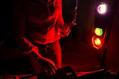 Midsection of woman holding illuminated red standing at night