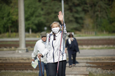 Rear view of man holding woman standing against blurred background