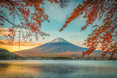 Scenic view of lake by mountain against cloudy sky