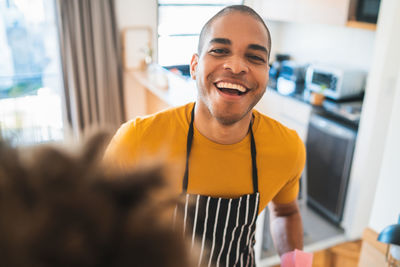 Portrait of a smiling young man against counter at kitchen