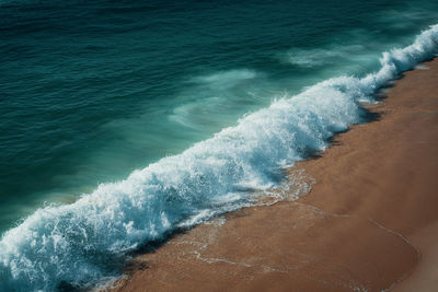 High angle view of waves rushing towards shore